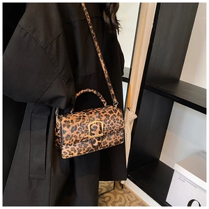 Détail du sac léopard avec boucle dorée et bandoulière réglable porté par un mannequin