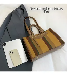 Detail shot of striped canvas tote bag showing large capacity for iPad and phone storage