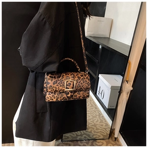 Détail d'un mini sac bandoulière tendance à motif léopard avec boucle en métal doré