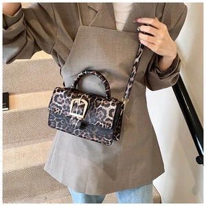 Détail du sac bandoulière tendance à imprimé léopard avec grande boucle dorée