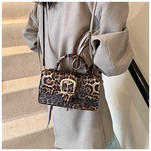 Sac à bandoulière léopard tendance avec boucle dorée porté par un mannequin chic