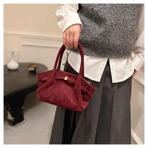 Détail du cabas vintage en daim bordeaux avec plis élégants et boucle dorée chic