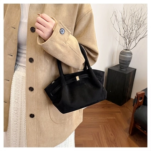 Détail du grand sac cabas en daim noir avec boucles dorées et bandoulière élégante