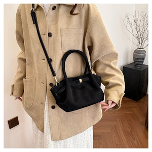 Détail du sac cabas en daim noir avec boucle dorée et bandoulière réglable