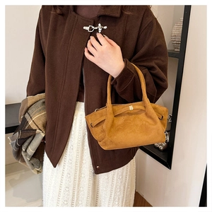 Détail du sac cabas vintage en daim moutarde avec plis et ferrures métalliques dorées