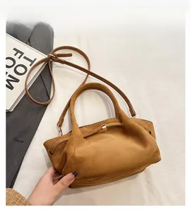 Détail du sac cabas en daim marron avec boucle carrée dorée et bandoulière réglable pratique