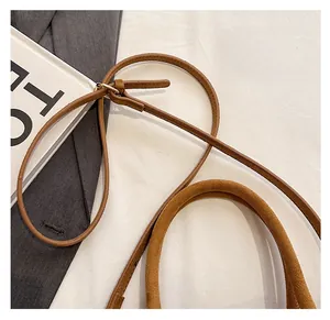 Détail de la bandoulière réglable et de l'anse de ce sac fourre-tout marron mat