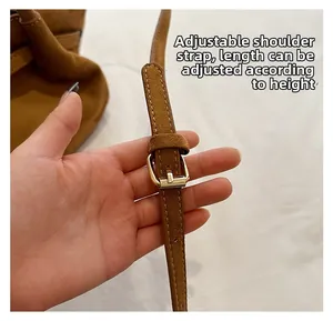 Détail de la bandoulière réglable avec boucle dorée sur sac cabas en daim marron