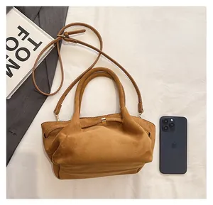 Détail du grand cabas en daim marron avec comparaison de taille par rapport au téléphone