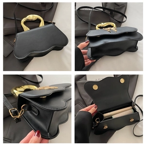 Detail view of black handbag showing ribbon hardware, wave edges, and interior space