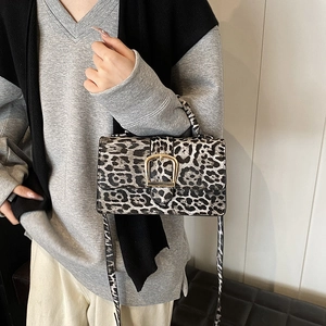 Sac bandoulière chic à imprimé léopard avec boucle dorée porté par un mannequin