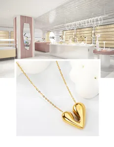 Gros plan d'un pendentif cœur plaqué or 18 carats avec finition polie sur une chaîne fine