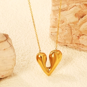 Collier avec pendentif cœur 18K au design fluide sur un fond en pierre texturée