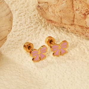 Cute golden bow earrings with pink enamel finish on natural stone background