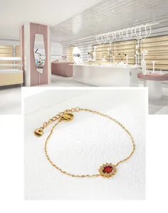 Detailed macro view of gold chain bracelet with red gem flower cluster and S.Steel tag