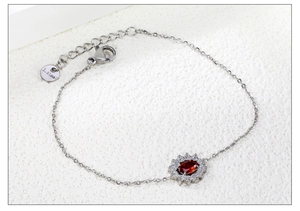 Detailed macro view of red zircon flower pendant and stainless steel chain with clasp