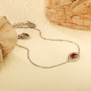 Elegant silver stainless steel bracelet featuring a pear-cut red zircon and white stones
