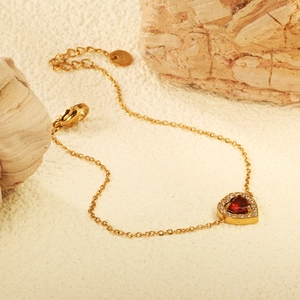 Bracelet cœur doré élégant avec zircon rouge et cristaux blancs sur fond de pierres