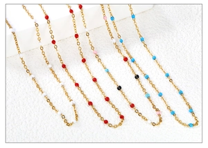 Detail view of gold stainless steel necklace featuring vibrant multi-colored enamel beads