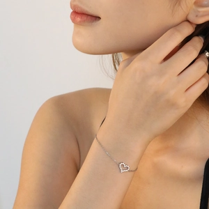 Macro shot of silver heart pendant with zircon inlay on a minimalist stainless steel chain