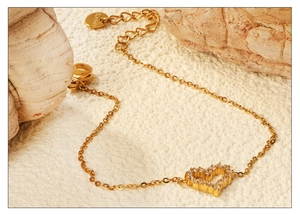 Detail of gold hollow heart charm on stainless steel chain with sparkling zircon stones