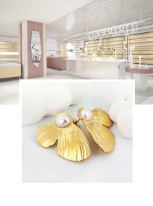 Close-up of golden ginkgo leaf earrings with white pearls in a French vintage style