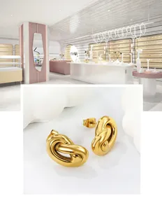 Detailed view of elegant gold-toned knotted stud earrings with a polished metallic finish