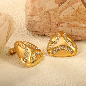 Minimalist gold triangular stud earrings with shimmering rhinestones on a stone surface