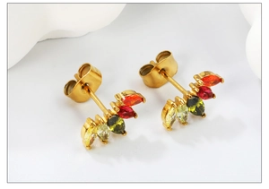 Détail de boucles d'oreilles losanges dorées avec zircons colorés en dégradé