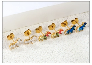 Détail de boucles d'oreilles dorées en éventail avec gemmes marquise colorées et fermoirs papillon