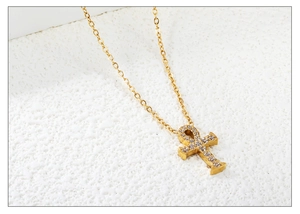 Macro-opname van vergulde Ankh-kruishanger met fonkelende zirkonia op een O-ketting