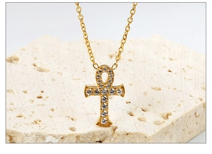 Macro-opname van gouden Ankh-hanger met zirkonia op een gestructureerde steen
