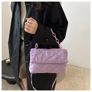 Detail of lavender quilted nylon crossbody bag with chic plastic chain on model