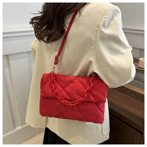 Détail du sac à bandoulière matelassé rouge avec grosse chaîne et sangle réglable