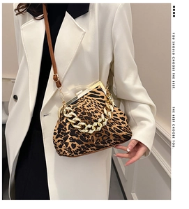 Detail of leopard print shell bag featuring a vintage gold clasp and chunky chain strap