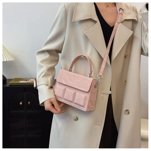 Detail view of pink structured box bag with chocolate block texture and logo on the flap