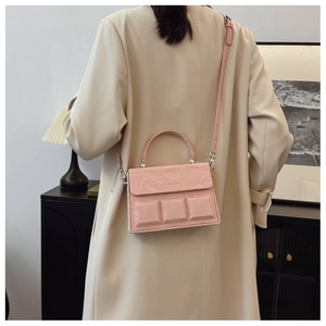 Detail of pink crossbody box bag with unique 3D square texture and silver metal hardware