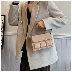 Detail of 3D rectangle embossed faux leather handbag with silver metal hardware and logo