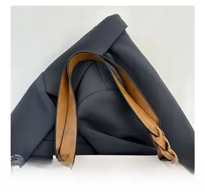 Detail of a brown woven leather strap on a stylish tote bag with minimalist texture
