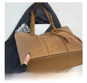 Detail of vintage brown tote bag with woven handles and white contrast stitching
