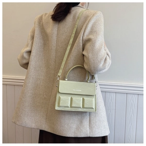 Detailed side view of light green box bag with embossed squares and marble texture