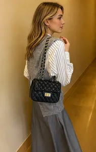 Schwarze Stepptasche mit goldener Kette an der Schulter für modernen modischen Stil