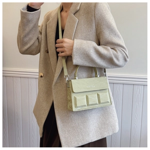 Detailed view of light green embossed box bag with pleated texture and silver hardware