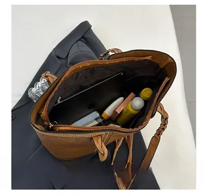 Internal view of a brown leather tote bag showing large capacity for tablets and cosmetics