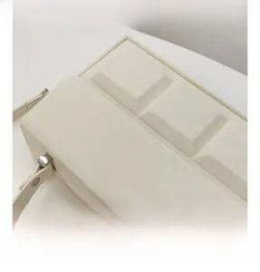 Detailed side view of off-white box bag featuring geometric keyboard-style embossing