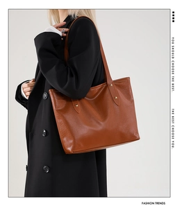 Detailed side view of large caramel tote bag featuring crocodile embossed leather texture