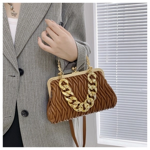Detailed view of brown ruched cloud bag with vintage gold clasp and chunky chain link strap