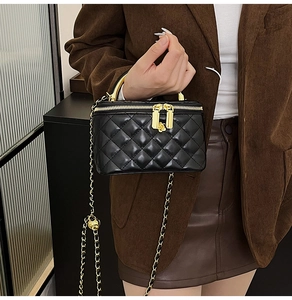Détails du mini sac noir matelassé avec ferrures camélia dorées et poignée en métal