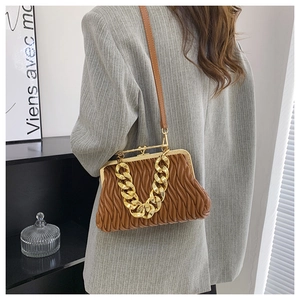 Detail of brown pleated shell bag with vintage metal frame and chunky gold chain
