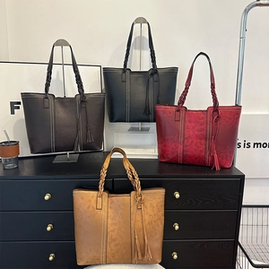 Set of four large faux leather tote bags in brown, black, and red with woven handles